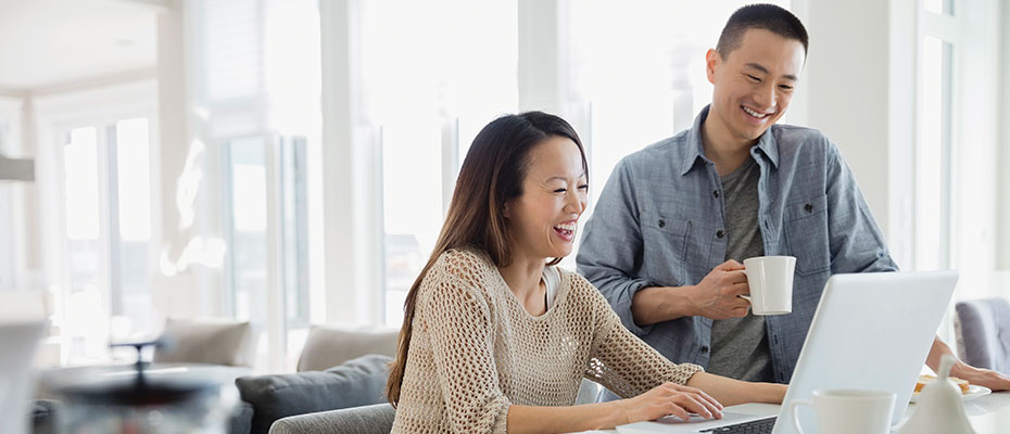 Man and woman researching life insurance on laptop